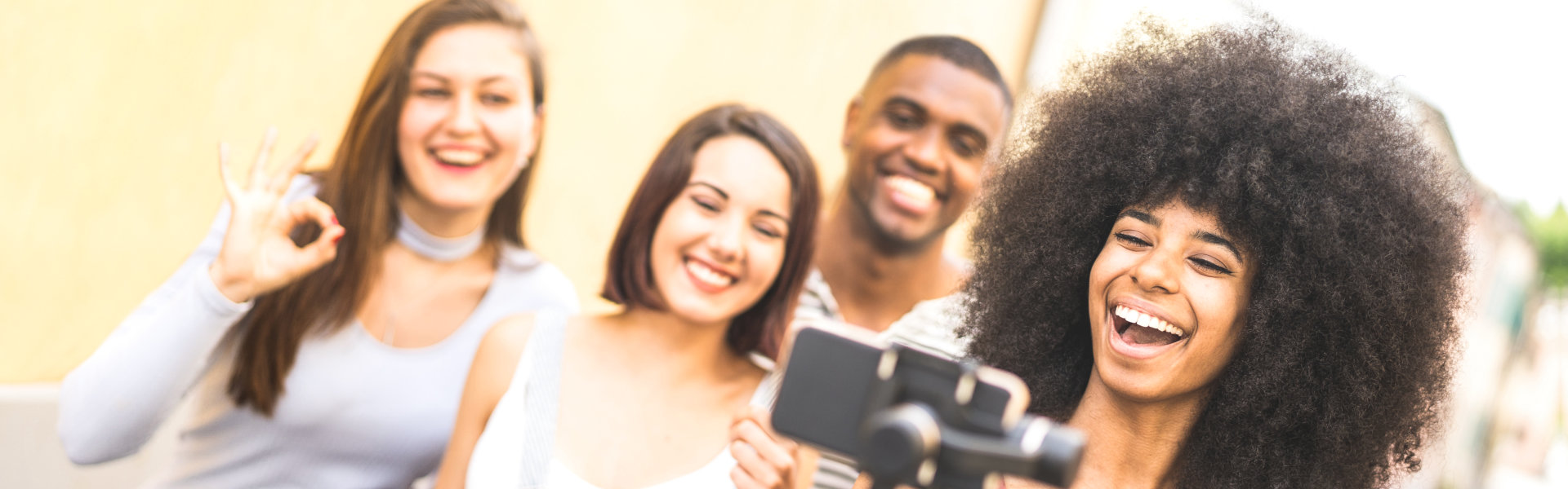 Millennial people taking video selfie with stabilized mobile phone